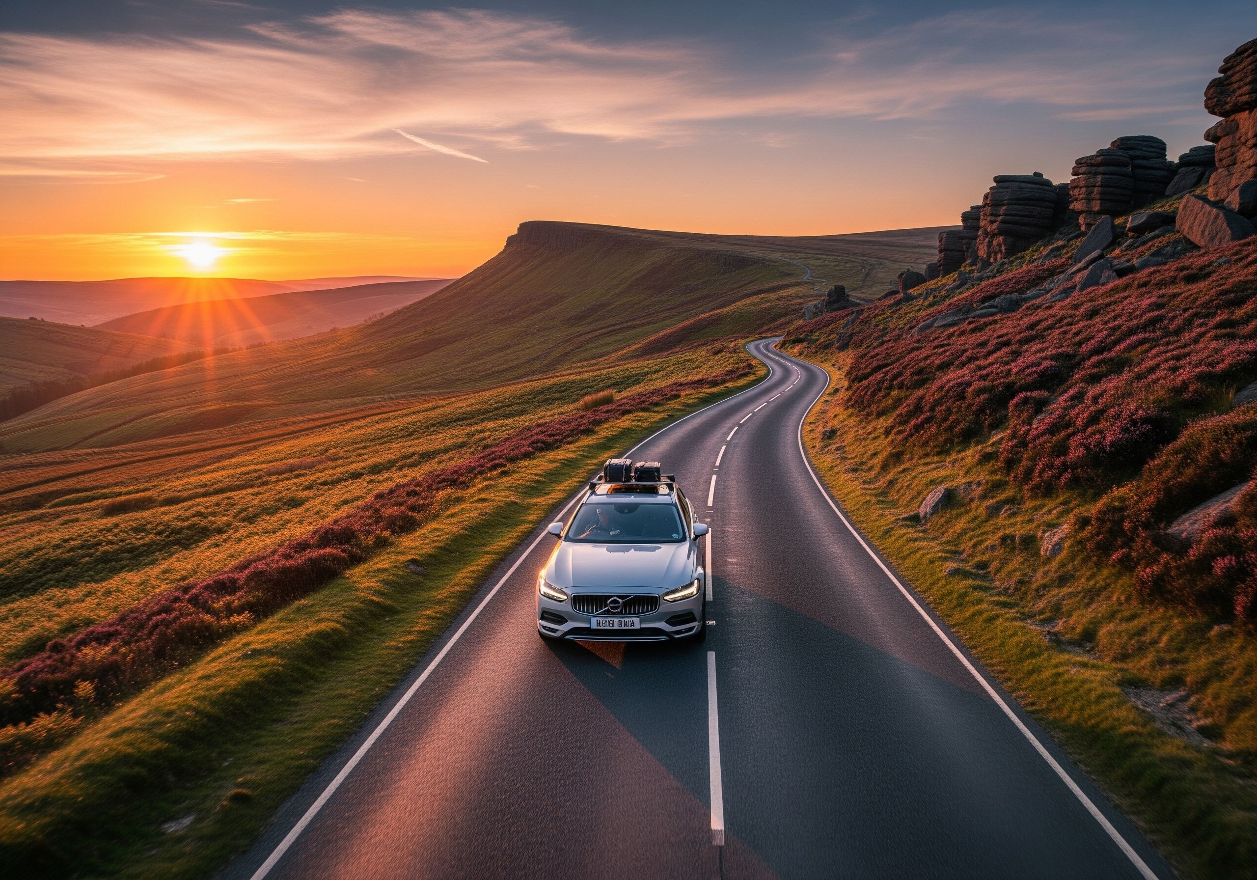 A car driving on a scenic road towards the horizon.